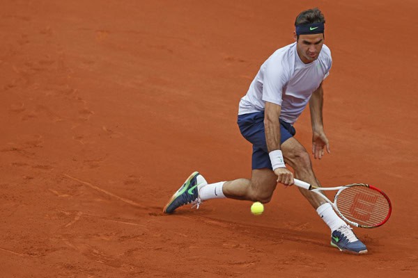 Roger Federer របស់ស្វ៊ីស វាយកូនបាល់ត្រឡប់ទៅវិញនៅពេលប្រកួតជាមួយ Pablo Carreno-Busta ក្នុងជុំទី១នៃ French Open